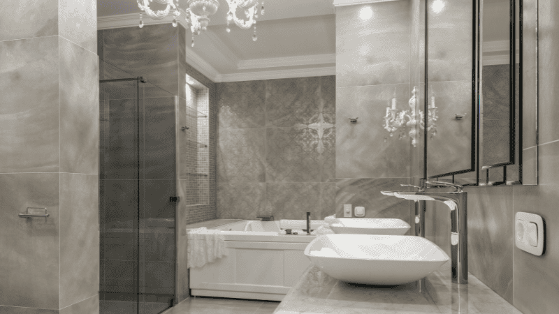 A cool-toned crystal chandelier illuminated a small bathroom.