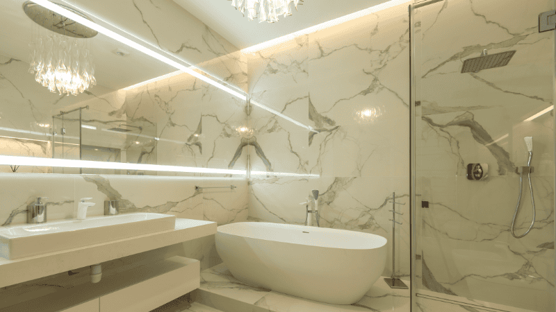 The crystal chandelier is hung above the bathtub.
