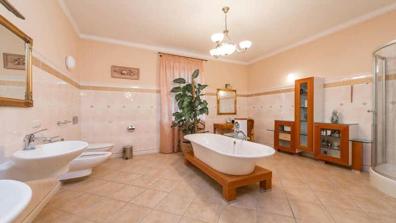 Luxury spacious bathroom in traditional style with ornate metal work chandelier