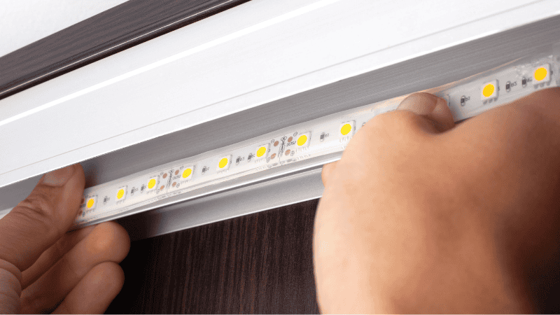 A man is installing a light strip.