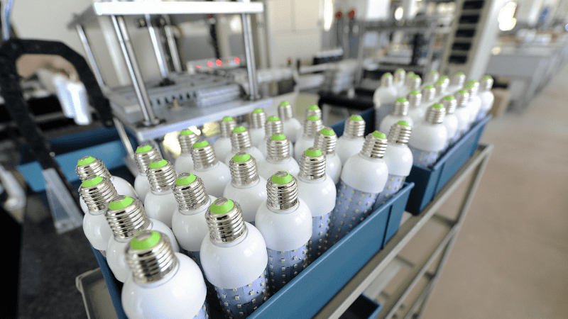 Pictures of the production process of LED bulbs in a factory.